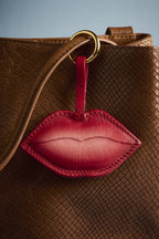 Charm Beso de cuero Arthelier colgado en un bolso