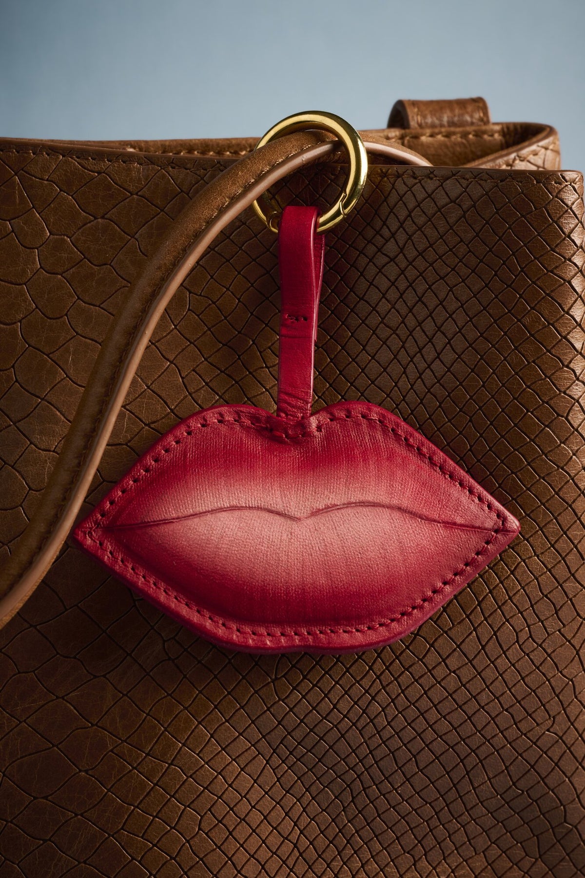 Charm Beso de cuero Arthelier colgado en un bolso