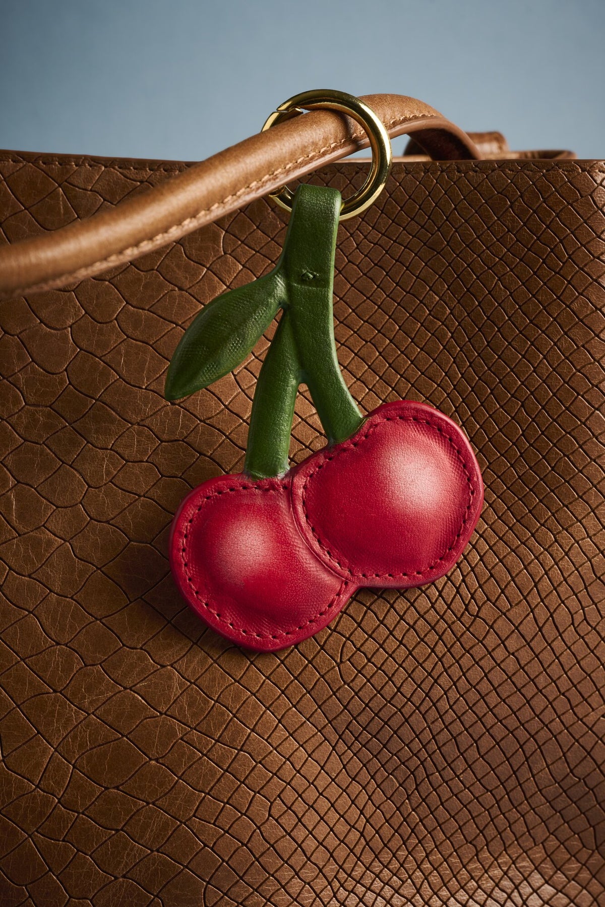 Charm Cereza de cuero Arthelier colgado en un bolso