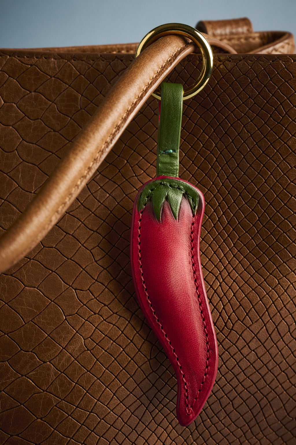 Charm Chilli de cuero Arthelier colgado en un bolso