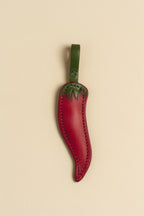 Charm Chilli de cuero Arthelier sobre fondo crema