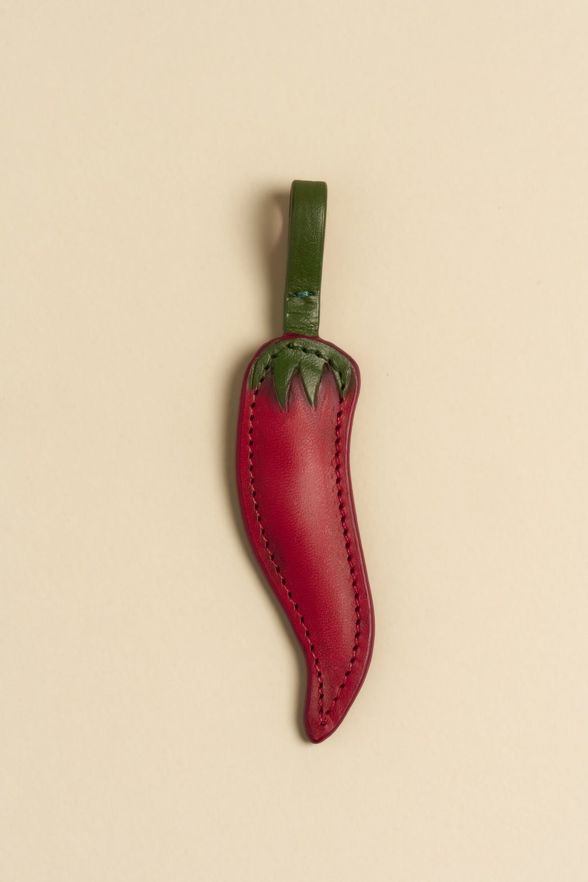 Charm Chilli de cuero Arthelier sobre fondo crema