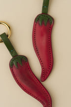 Detalle de dos Charms Chilli de cuero rojo con tallo verde
