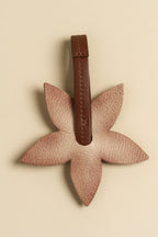 Charm Flor de cuero Arthelier sobre fondo crema